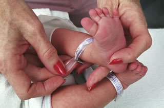 Hospital identification tag being put onto a newborn baby's foot